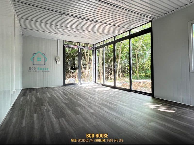 Một phần hệ vách được làm từ vật liệu kính cường lực giúp lấy ánh sáng từ bên ngoài tạo nên không gian thoáng mát, sáng sủa cho căn nhà